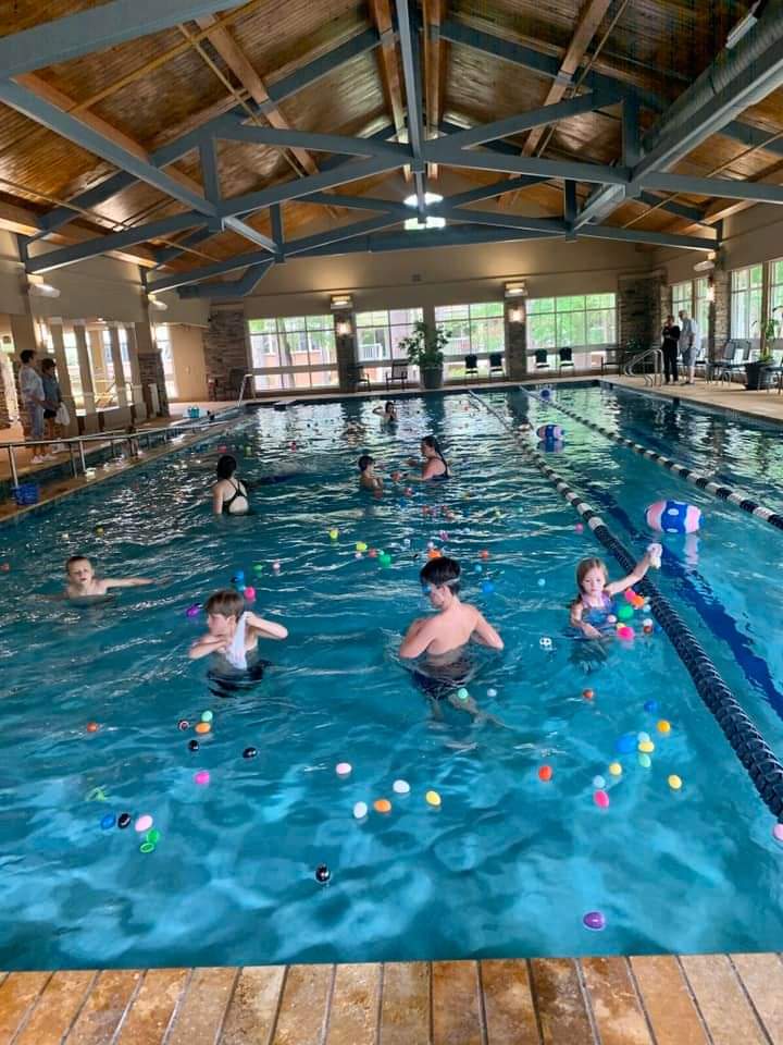 children swimming in the pool grabbing Easter eggs