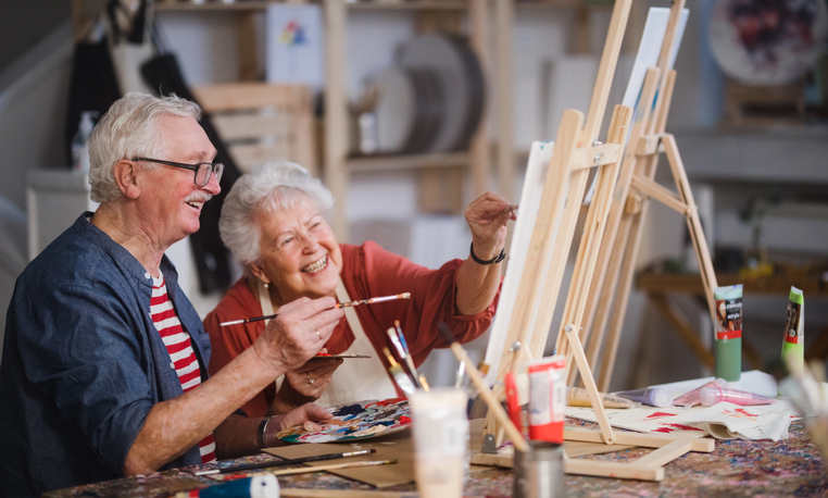 Happy senior friends painting together at art class. Happy senior friends painting together at art class.