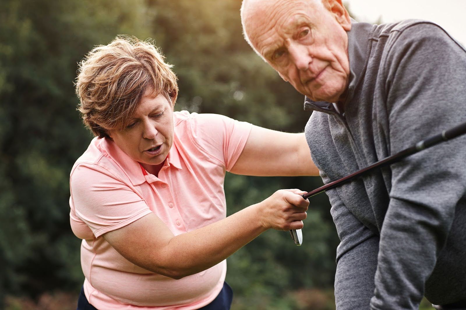 Senior couple practicing golf swing. 