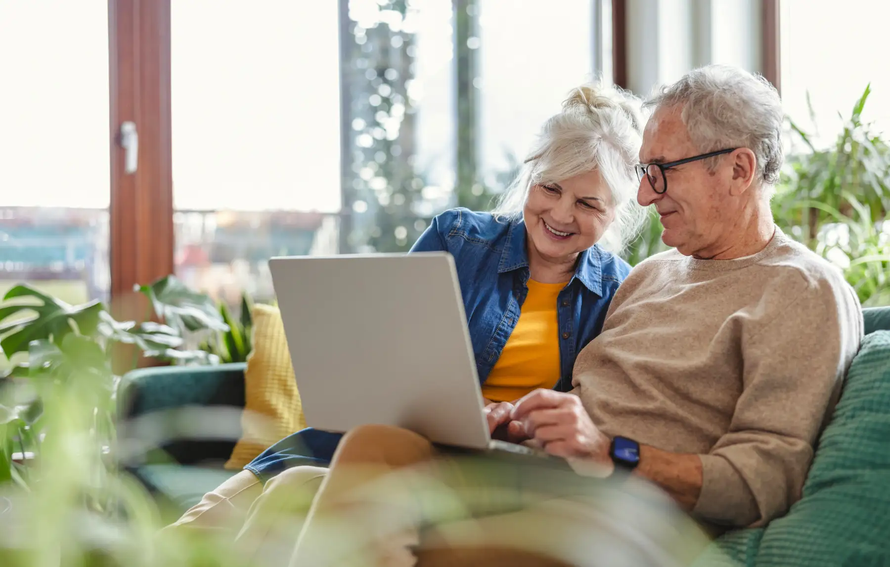 a senior couple at home using their laptop