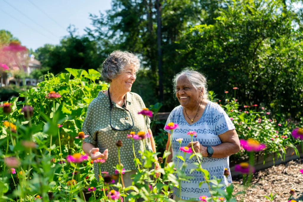 Two seniors women smiling and exploring spring activities for seniors while discussing things to do In Evans and Augusta GA for Seniors near Brandon Wilde.