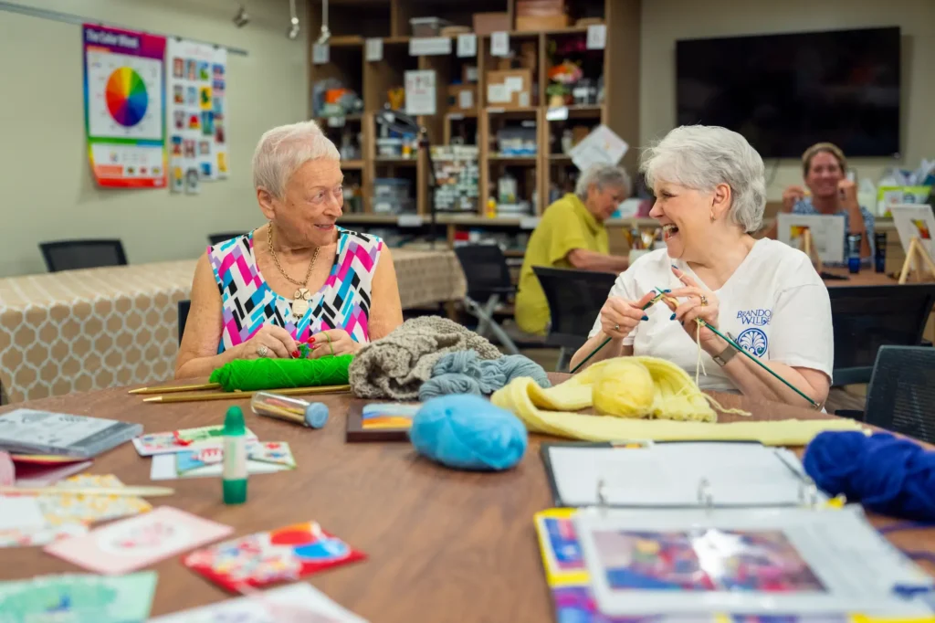 two ladies knitting in the craft room at Brandon Wilde in Evans, GA.