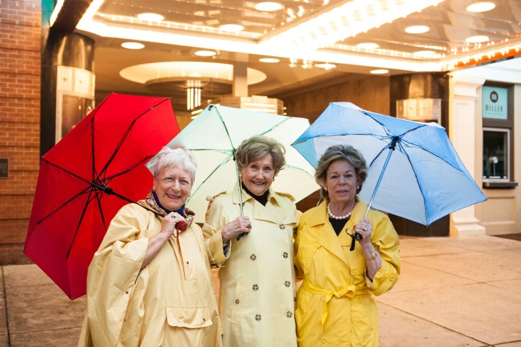 a group of senior women holding umbrellas