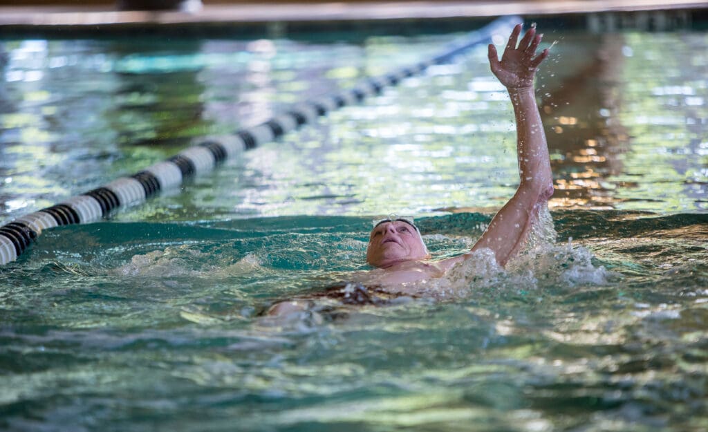 a senior man swimming in a pool