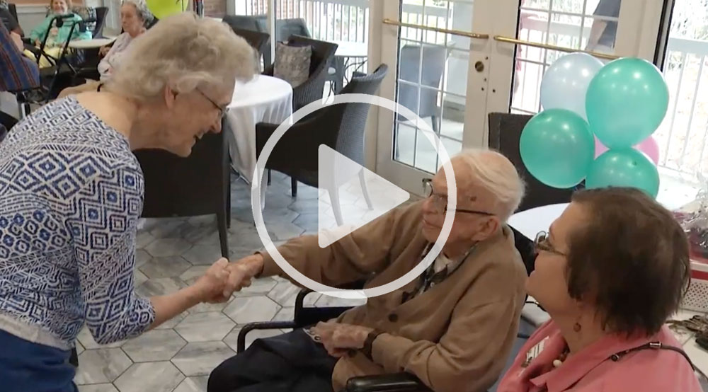 Joe Gwaltney shaking hands with another resident at his birthday party