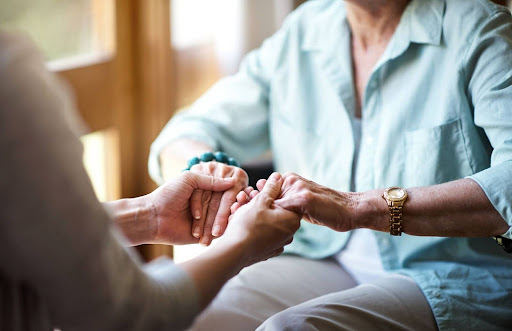 daughter and senior mother holding hands