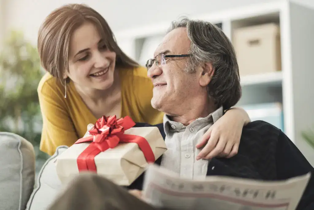 A woman giving a gift to a senior with dementia at Brandon Wilde.