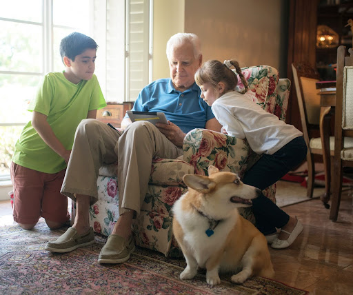 senior with his family and corgie dog
