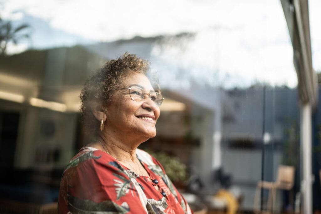 senior woman smiling and looking out window
