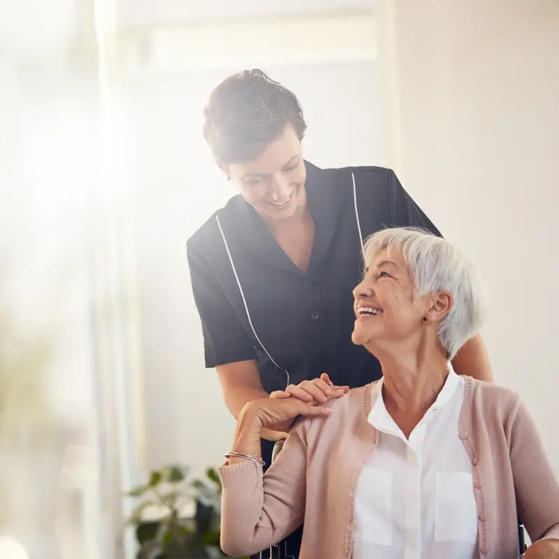 Nurse assisting a senior woman at Brandon Wilde while discussing personal care vs. memory care.